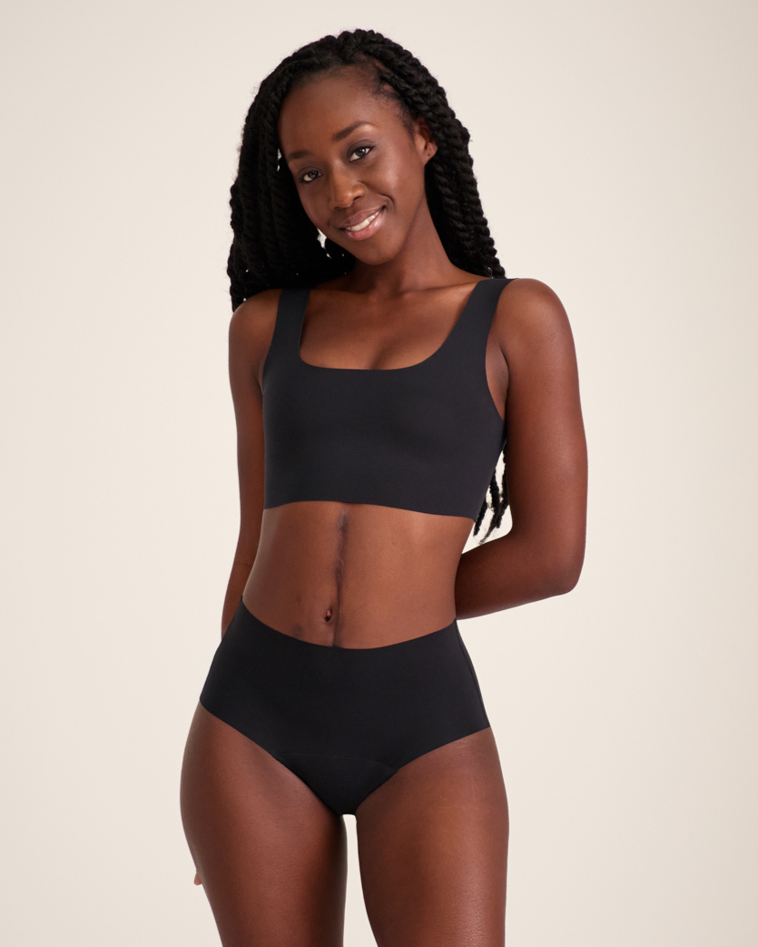Modell trägt ooia Highwaist Seamless in Schwarz – nahtlose Periodenunterwäsche mit hohem Bund.