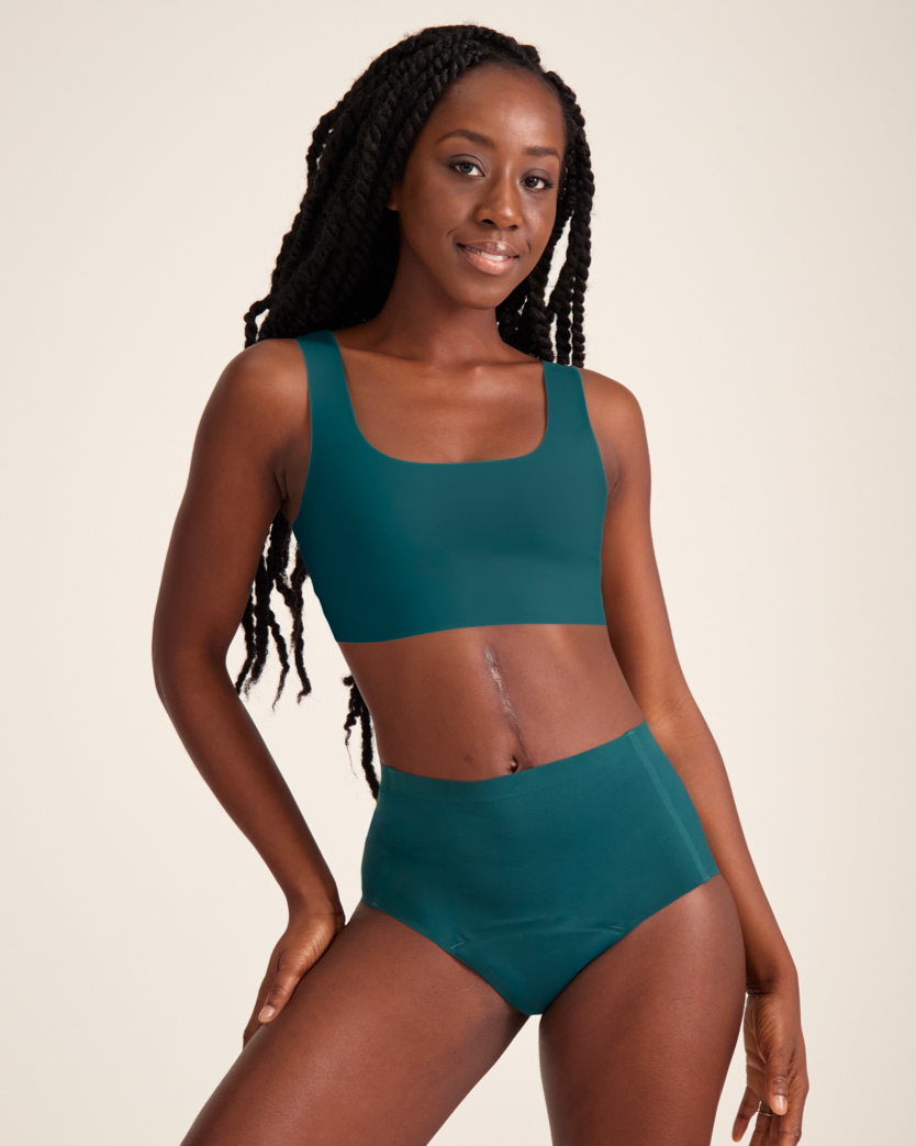 Modell trägt ooia Highwaist Seamless in Grün – nahtlose Periodenunterwäsche mit hohem Bund.