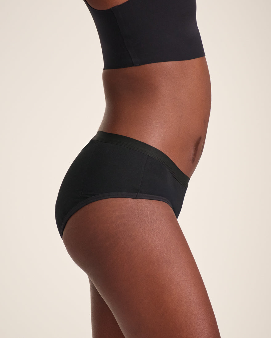 Modell trägt ooia Hipster Extra Strong in Schwarz – Periodenunterwäsche im klassischen Schnitt, mit starker Saugstärke.