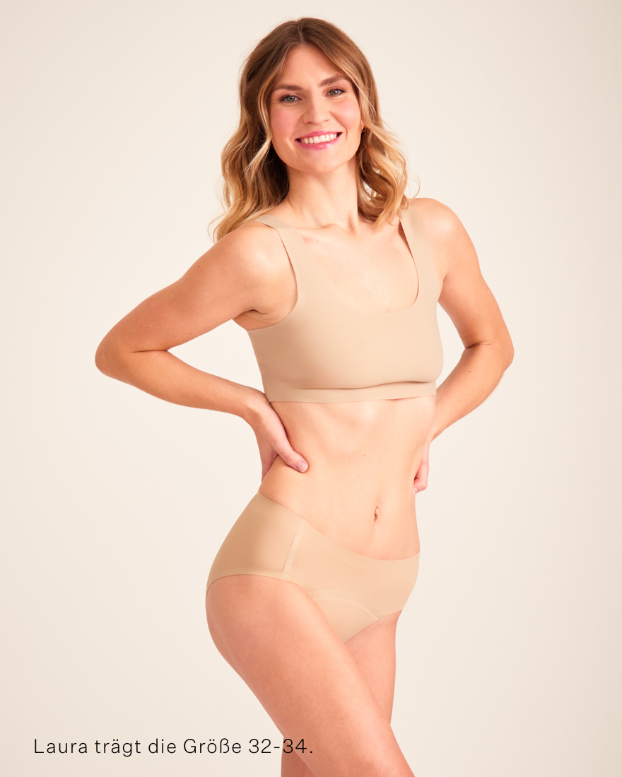 Modell trägt ooia Hipster Seamless in Beige – nahtlose Periodenunterwäsche.