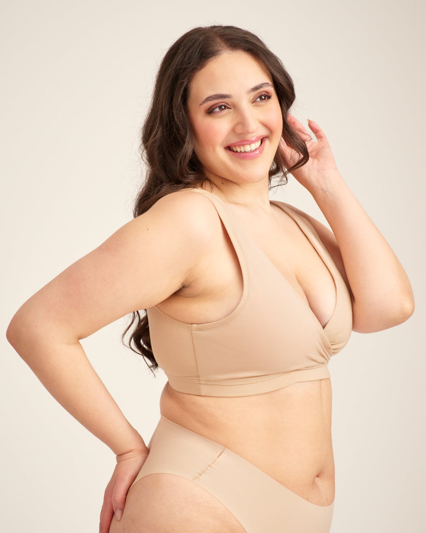 Modell trägt ooia Moms Still-BH in Beige – Still-BH ersetzt Stilleinlagen mit praktischer Pull-Down Funktion.