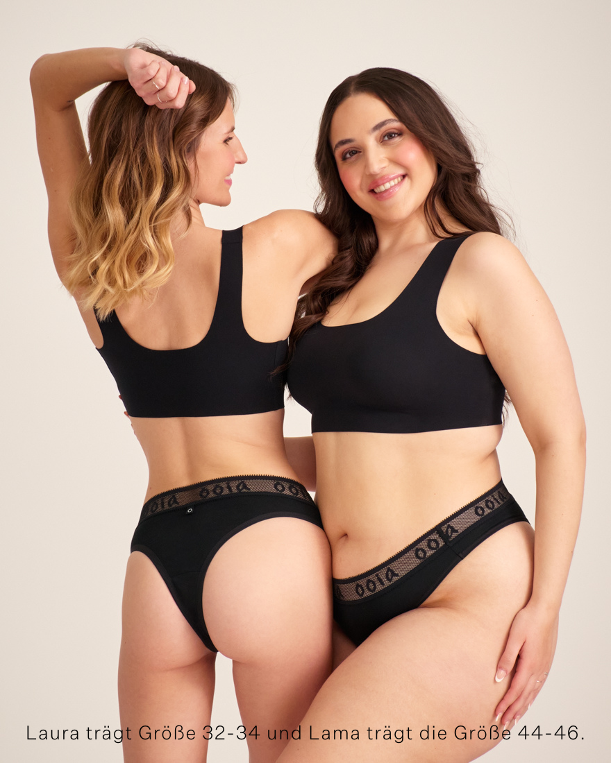 Zwei Models unterschiedlicher Konfektion tragen ooia Brazilian in Schwarz – Periodenunterwäsche mit breitem Mash-Bund mit ooia Logo.