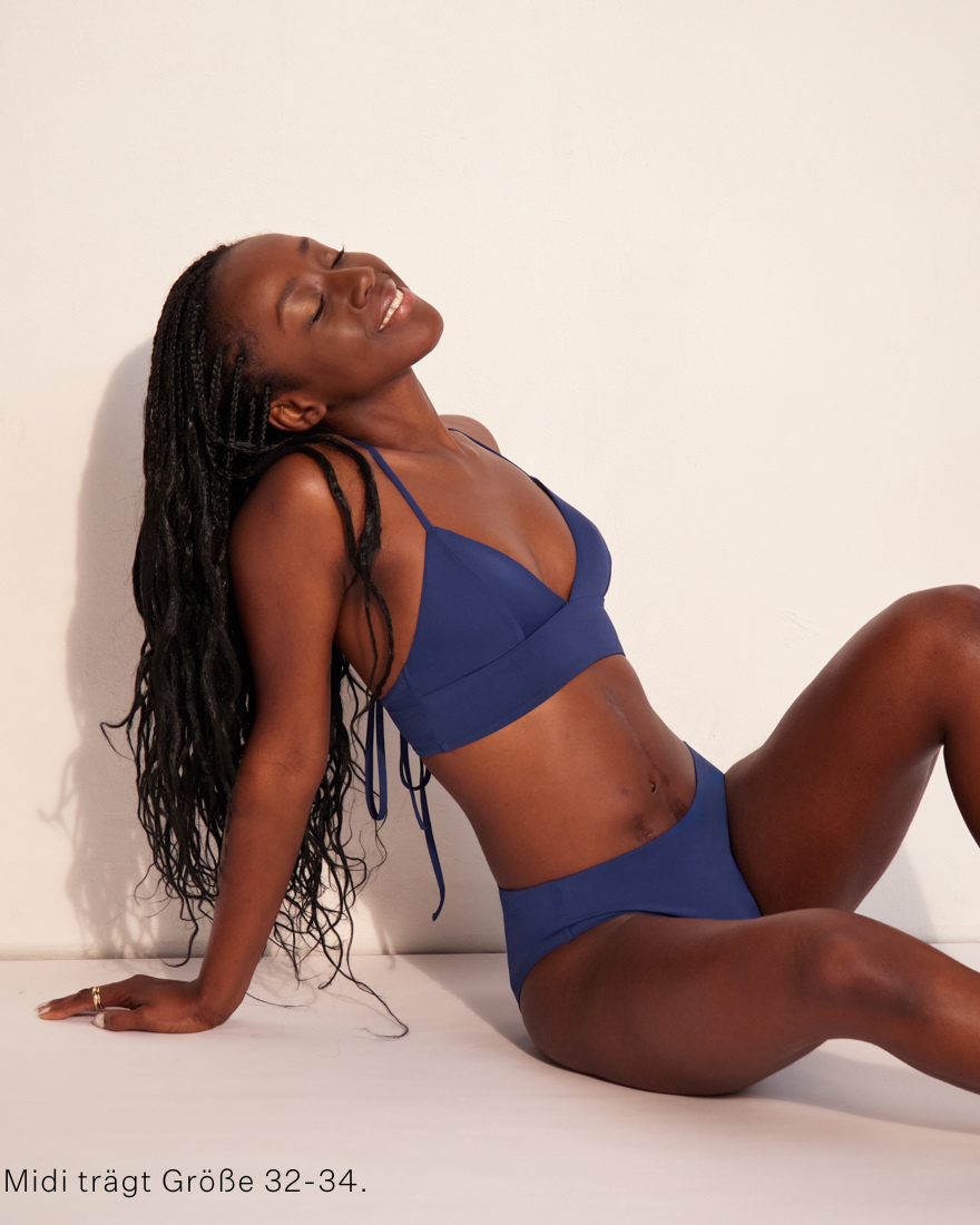 Modell trägt ooia Beach Triangle Top in Ozeanblau – Bikini-Top im klassischen Triangle Shape mit verstellbaren Trägern.