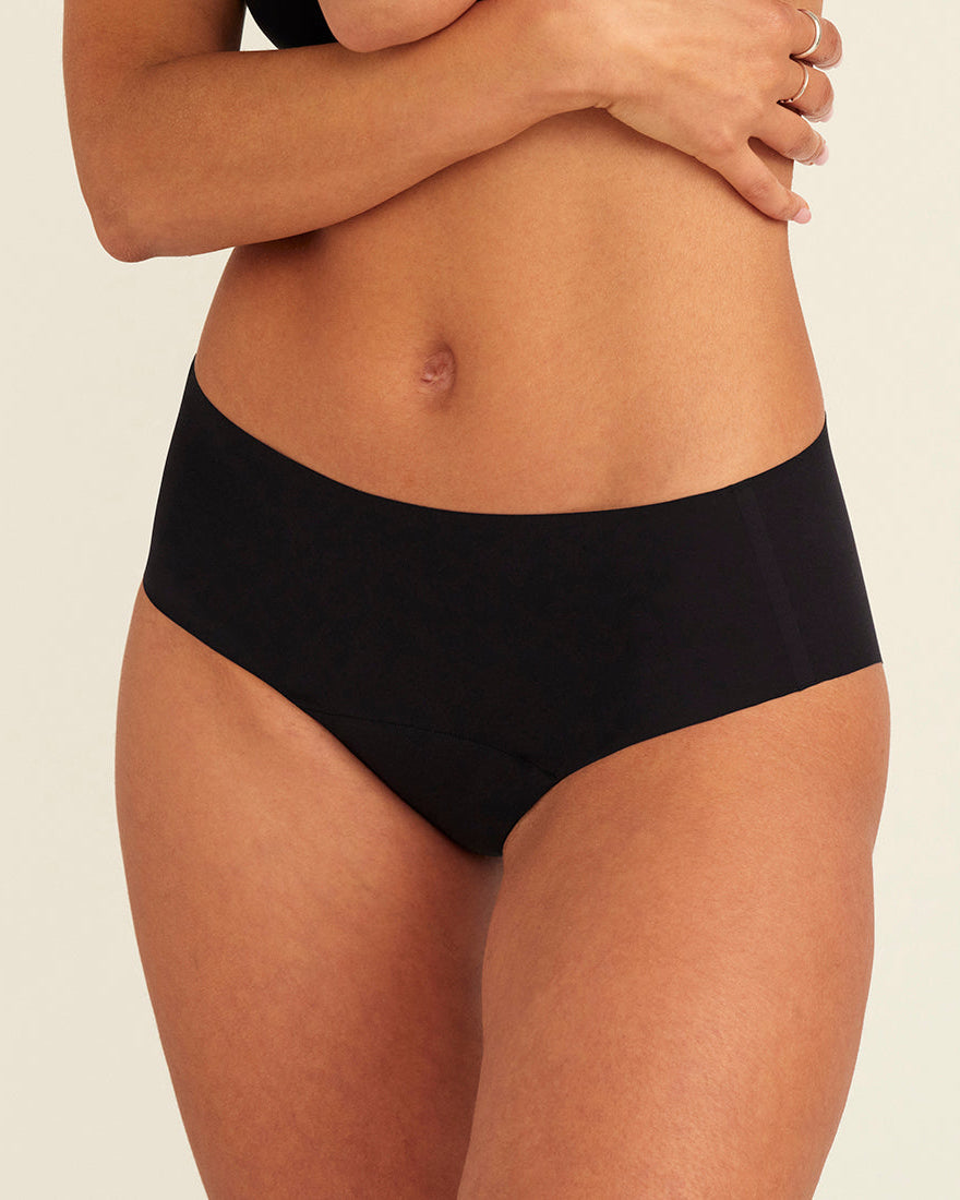 Modell trägt ooia everyday Hipster Seamless in Schwarz – nahtlose Unterwäsche, die Slipeinlagen ersetzt.