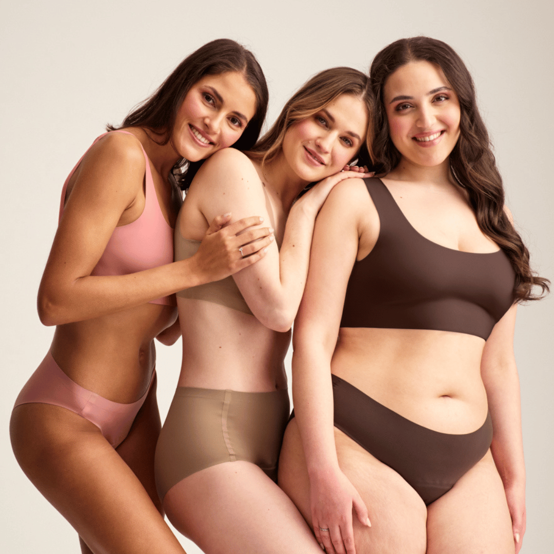 Drei Models präsentieren ooia Periodenunterwäsche . Stehend. Models lehnen sich aneinander an. 