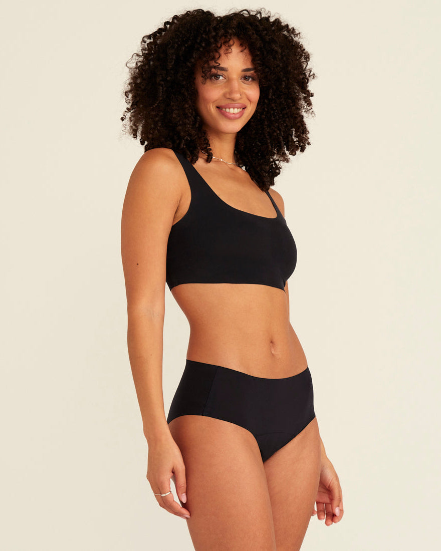 Modell trägt ooia Hipster Seamless Extra Strong in Schwarz – nahtlose Unterwäsche für eine starke Periode