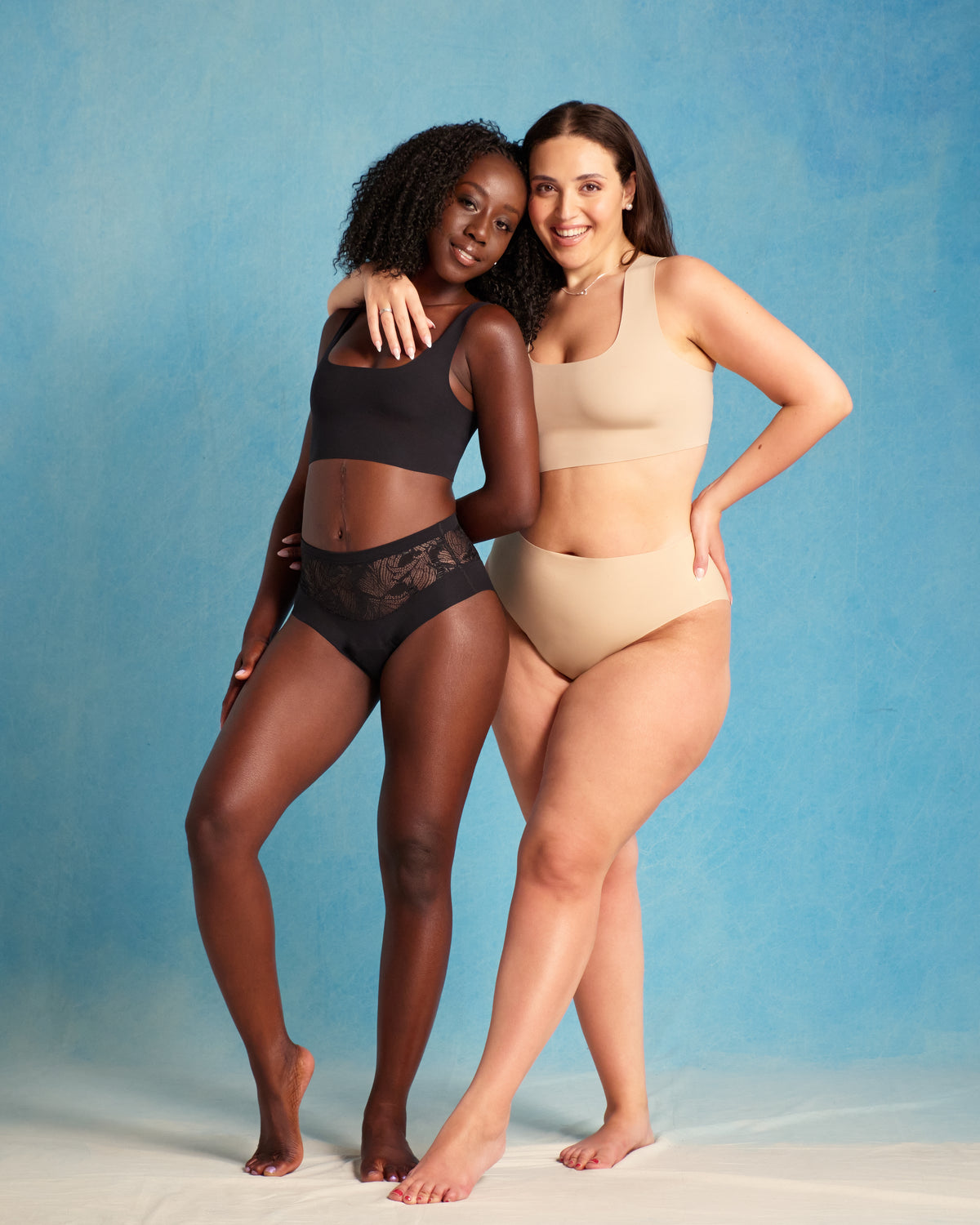 Zwei Models präsentieren ooia Periodenunterwäsche: Highwaist Seamless Lace Extra Strong schwarz und Highwaist Seamless beige