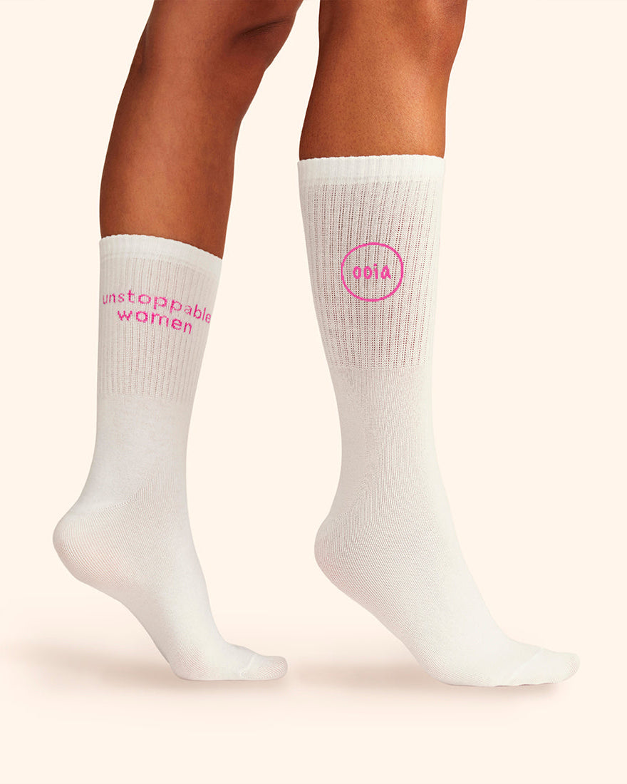 Modell trägt weiße wadenhohe  ooia Socken mit dem pinken Aufdruck: Unstoppable Woman