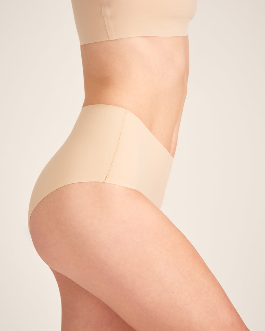 Modell trägt ooia Highwaist Seamless in Beige – nahtlose Periodenunterwäsche mit hohem Bund.