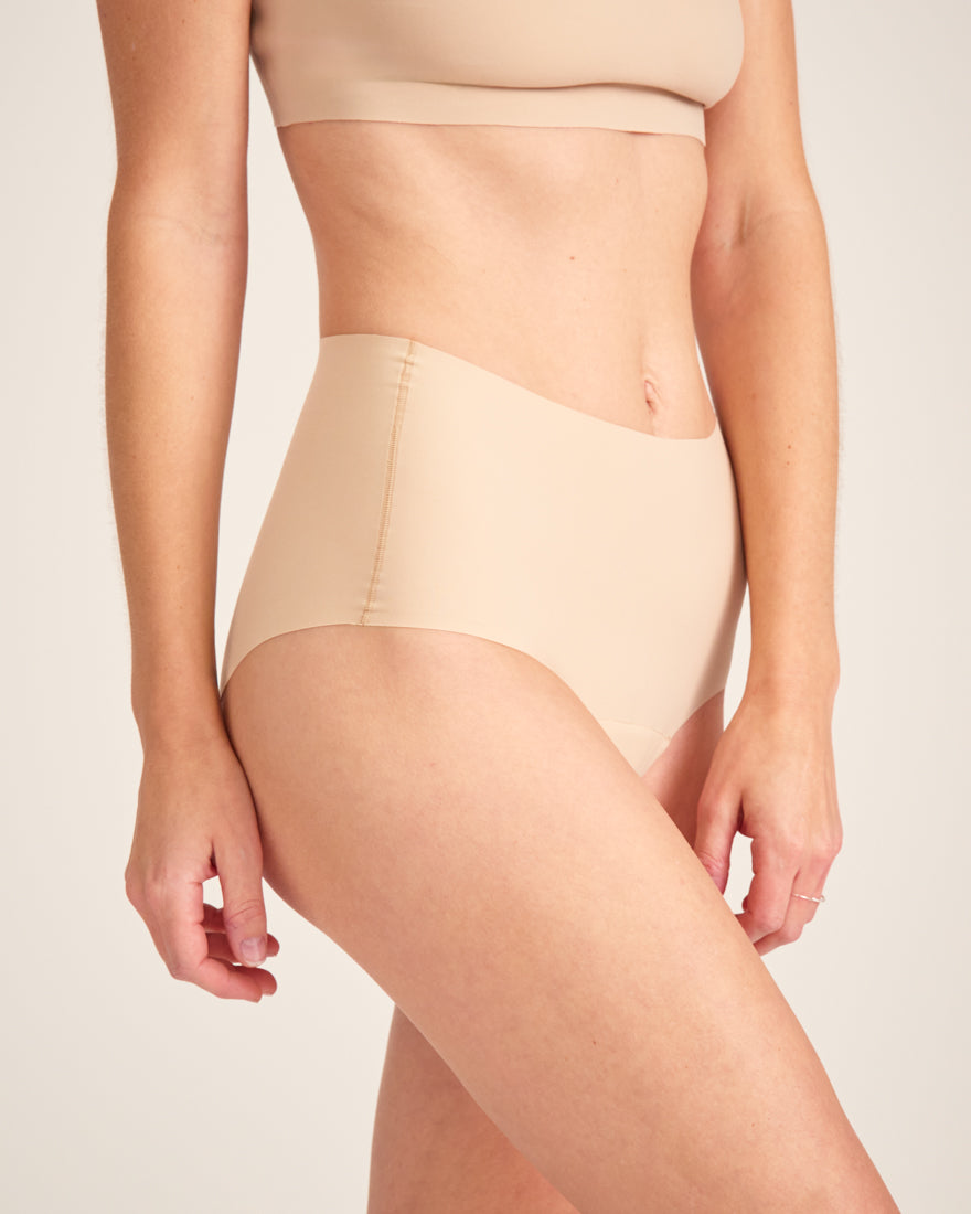 Modell trägt ooia Highwaist Seamless in Beige – nahtlose Periodenunterwäsche mit hohem Bund.