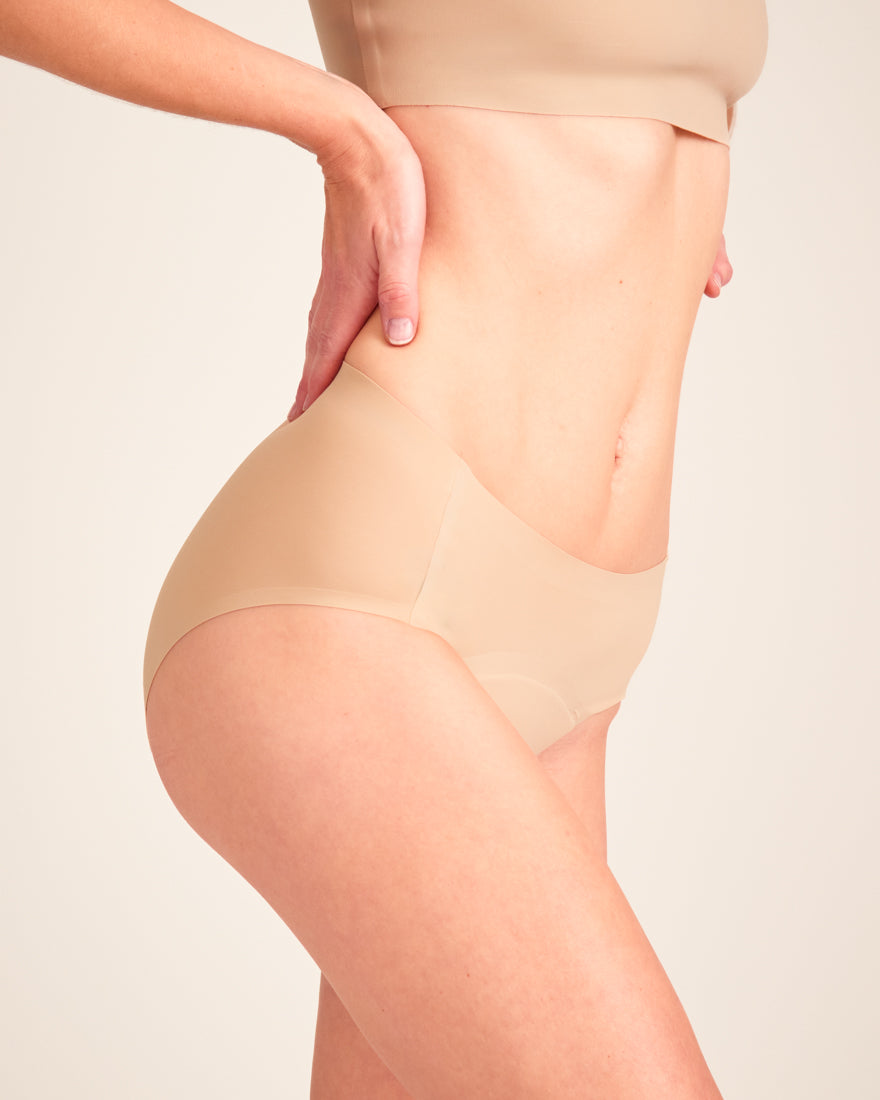 Modell trägt ooia Hipster Seamless in Beige – nahtlose Periodenunterwäsche.