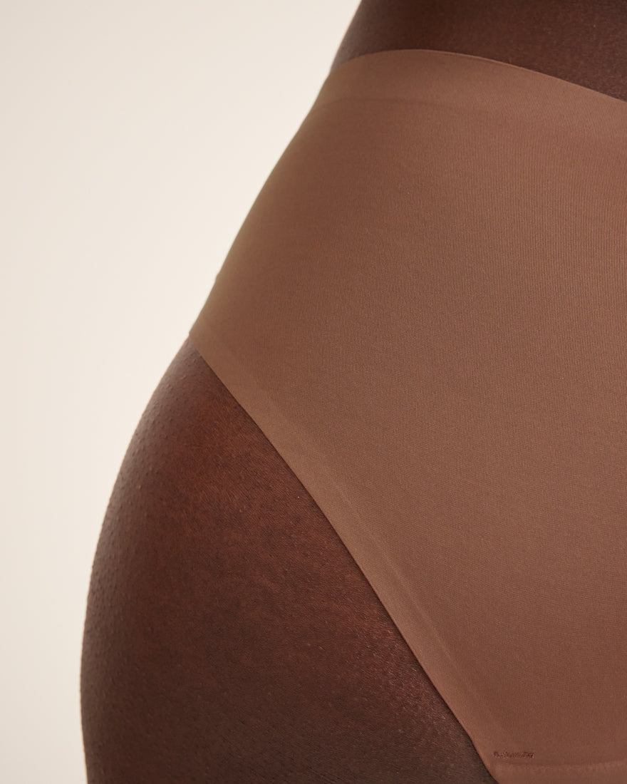 Modell trägt ooia Hipster Seamless in Braun – nahtlose Periodenunterwäsche. Detailansicht.
