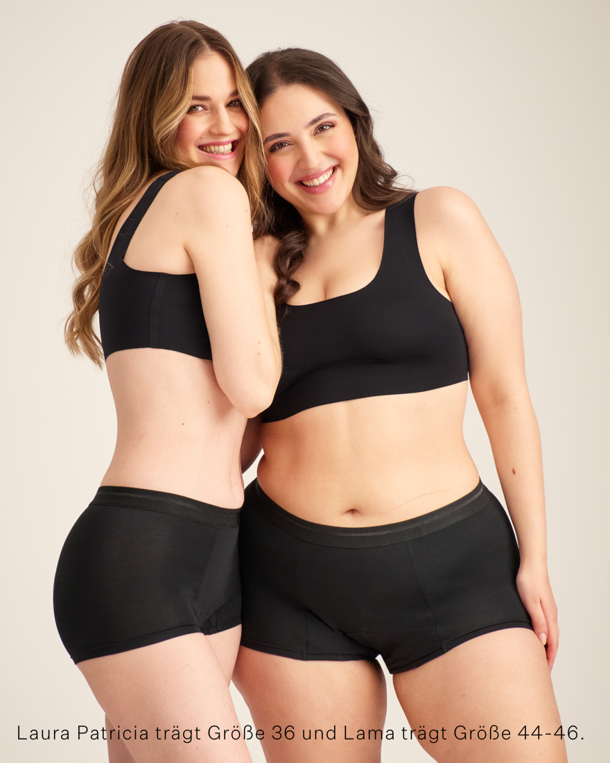 Zwei Models unterschiedlicher Konfektionen tragen ooia Shorty Extra Strong in Schwarz – Periodenunterwäsche mit breitem Bund und starker Saugstärke.