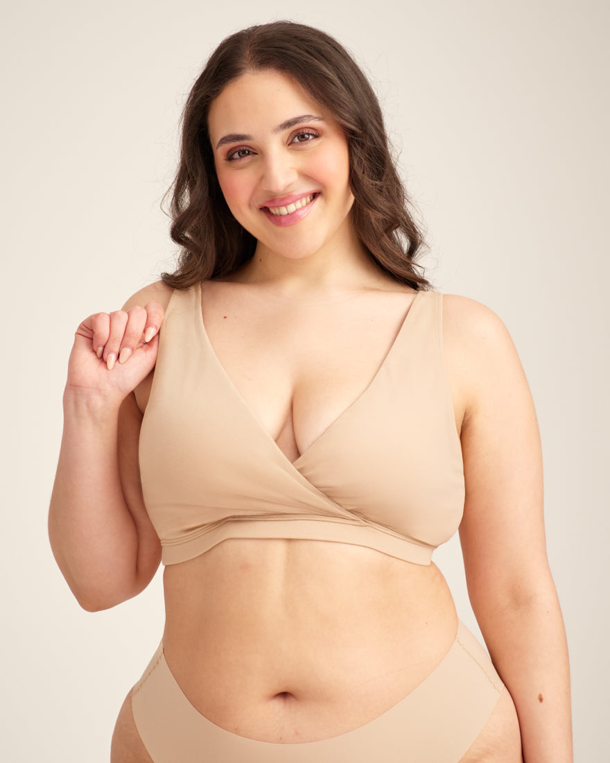 Modell trägt ooia Moms Still-BH in Beige – Still-BH ersetzt Stilleinlagen mit praktischer Pull-Down Funktion.