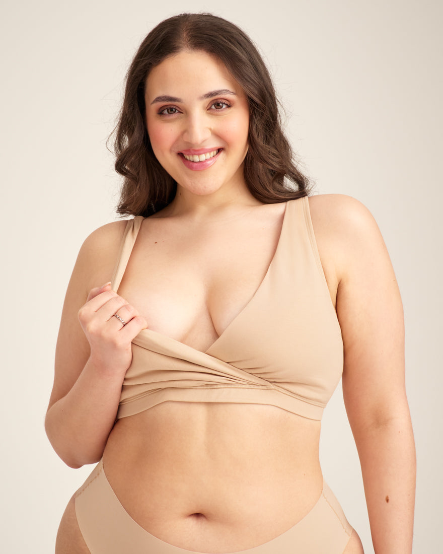 Modell trägt ooia Moms Still-BH in Beige – Still-BH ersetzt Stilleinlagen mit praktischer Pull-Down Funktion. Model demonstriert Pull-Down Funktion.