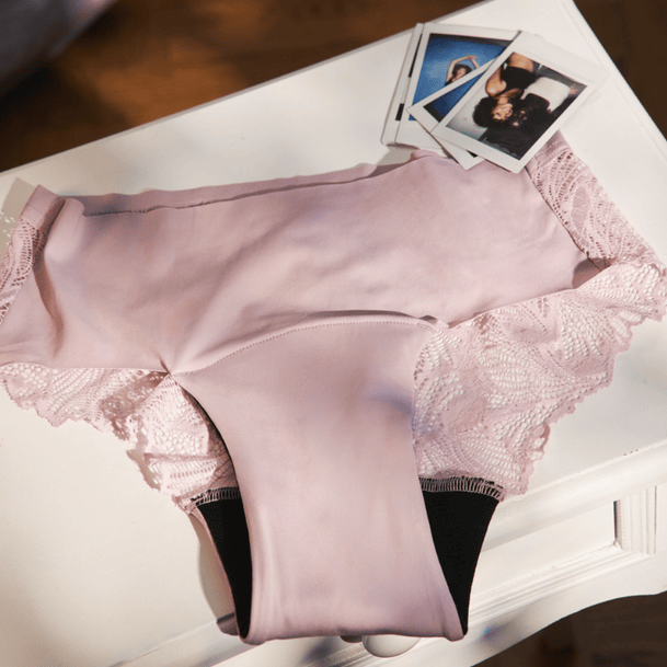 Ooia Periodenunterwäsche Teens Hipster Seamless Lace in muted mauve wird liegend auf Tisch präsentiert.