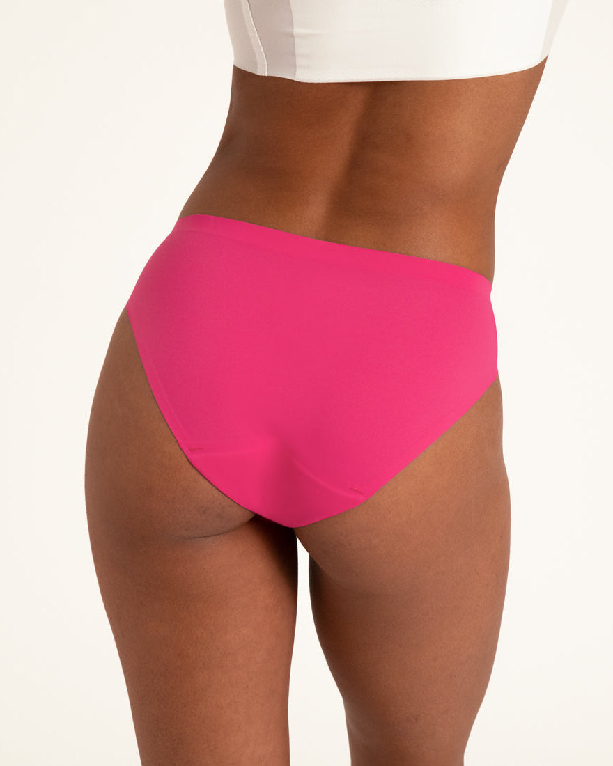 Model trägt ooia Periodenunterwäsche Slip Seamless in hot pink im nahtlosen Design zu sehen von hinten.
