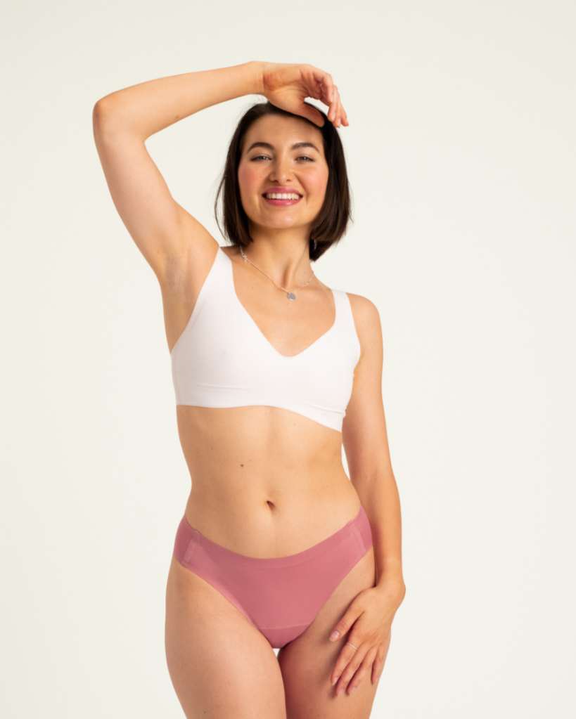 Modell trägt ooia Slip Seamless in Dusky Pink – nahtlose Periodenunterwäsche im klassischen Schnitt. 